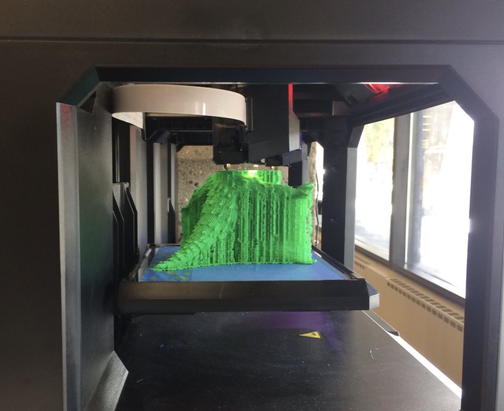 3D printer printing a three-dimensional green model for a class project with futuristic technology