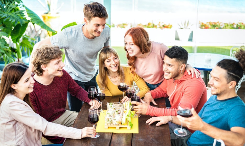 Trendy young people having fun together drinking wine at penthouse